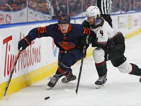 Dec 7, 2022; Edmonton, Alberta, CAN; Edmonton Oilers forward Dylan Holloway (55) and Arizona Coyotes defensemen Juuso Valimako (4) battle along the boards for a loose puck during the third period at Rogers Place.