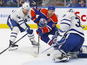 Maple Leafs goaltender Ilya Samsonov  makes a save on Oilers' Connor McDavid with defenceman Morgan Rielly trying to help, during the third period at Rogers Place on Wednesday night.