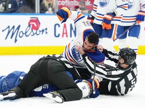 Oilers' Evander Kane (91) fights with Toronto Maple Leafs' Michael Bunting  during the third period at Scotiabank Arena on Saturday night.