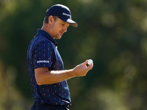 Justin Rose looks at his golf ball during the first round of the Valspar Championship. Golf's governing bodies are threatening to limit how far the balls can fly in the air.