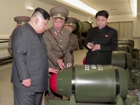 A screen grab shows North Korean leader Kim Jong Un, left, inspecting nuclear warheads at an undisclosed location in this undated still image used in a video.