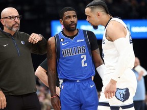 Dallas Mavericks head coach Jason Kidd (left) talks with guard Kyrie Irving (2) as Memphis Grizzlies forward Dillon Brooks (24) listens in during the first half at FedExForum.