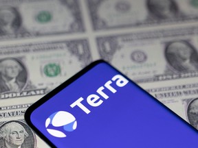 Smartphone with Terra logo is placed on displayed U.S. dollars in this illustration taken on May 11, 2022.