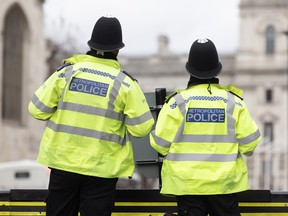 Metropolitan Police officers stand outside the Houses of Parliament on March 21, 2023 in London, England.