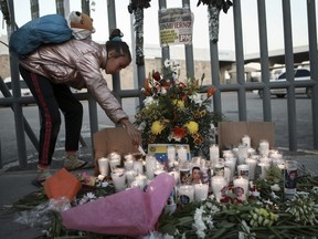 A girl lights candle during a vigil for the victims of a fire at an immigration detention centre that killed dozens in Ciudad Juarez, Mexico, Tuesday, March 28, 2023.