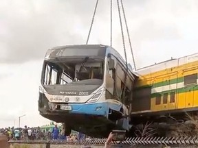 A bus is removed using a crane, after it collided with a train, in Ikeja, Lagos state, Nigeria, March 9, 2023 in this screen grab obtained from a handout video.