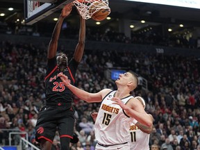 Toronto Raptors forward Chris Boucher (25) dunks against Denver Nuggets centre Nikola Jokic (15) during the first half at Scotiabank Arena on Tuesday night.