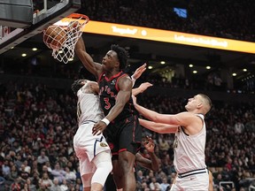 Toronto Raptors forward O.G. Anunoby (3) dunks a ball against Denver Nuggets center Nikola Jokic (15) and forward Aaron Gordon (50) during the first half at Scotiabank Arena.