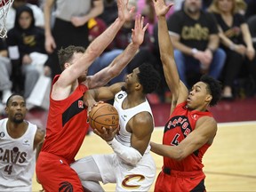 Cleveland Cavaliers guard Donovan Mitchell (45) drives to the basket between Toronto Raptors centre Jakob Poeltl (19) and forward Scottie Barnes.