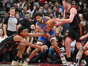Oklahoma City Thunder forward Olivier Sarr (30) battles for the ball with Toronto Raptors forward Scottie Barnes (4) and center Jakob Poeltl (19) in the second half at Scotiabank Arena.