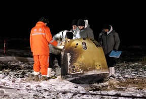 Researchers work next to Chang’e-5 lunar return capsule carrying moon samples, after it landed in northern China’s Inner Mongolia Autonomous Region, Dec. 17, 2020.