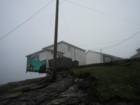 A general view shows a damaged house over an embankment in the aftermath of Hurricane Fiona in Port Aux Basques, Newfoundland, Sept. 27, 2022.