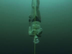 Czech freediver David Vencl dives to 52 metres under the ice of Lake Sils in one breath and wearing only a swimsuit in this picture taken from a video in Sils near St. Moritz, Switzerland March 14, 2023.