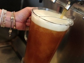 Pictured, a bartender fills a pitcher of beer in a downtown pub in Vancouver, BC., July 25, 2014.