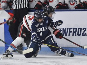 Yale's Elle Hartje (4) and Ohio State's Sophie Jaques (18) reach for the puck during the NCAA Women's Frozen Four hockey semifinal in State College, Pa., March 18, 2022.
