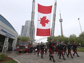 Toronto Fire Service Pipes and Drums lead the processional as  21 new names are added to Toronto Fallen Firefighter Memorial down at the "Last Alarm" monument located at Fire & Marine Station 334 at the Harbourfront in Toronto on June 12, 2022.