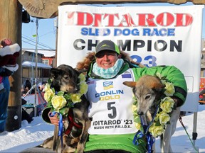 Iditarod winner Ryan Redington, whose grandfather Joe Redington Sr. is known as the founding father of the Iditarod Trail Sled Dog race, poses under the burled arch with his lead dogs Ghost and Sven at the finish line in Nome, Alaska, U.S. March 14, 2023.