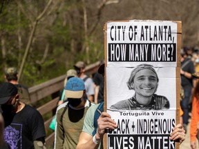 A person holds a sign for Manuel Paez Teran, a man that was shot and killed by police officers near the proposed building site for the Atlanta public training facility, during a march to Defend The Atlanta Forest on the South River Trail in Atlanta, March 4, 2023.