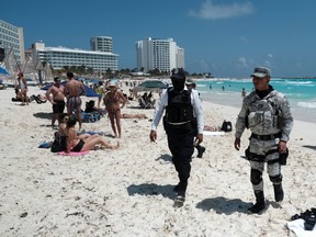 A police officer and a member of the National Guard patrol the Gaviota Azul beach during the beginning of the spring break in Cancun, Mexico, March 18, 2023.