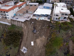 A backyard pool is left hanging on a cliffside after torrential rain brought havoc on the beachfront town of San Clemente, Calif., March 16, 2023.