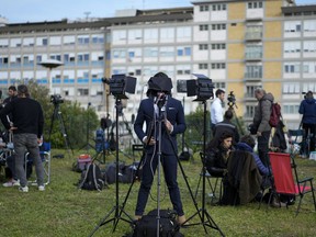 Members of the media set up their gear outside the Agostino Gemelli hospital under the rooms on the top floor normally used when a pope is hospitalized, in Rome, Thursday, March 30, 2023.