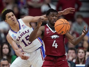 Arkansas guard Davonte Davis (4) is fouled by Kansas guard Kevin McCullar Jr. (15) in the second half of a second-round college basketball game in the NCAA Tournament, Saturday, March 18, 2023, in Des Moines, Iowa.