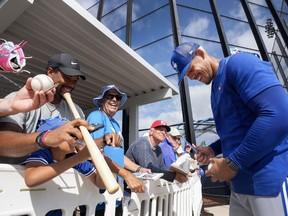 Toronto Blue Jays starting pitcher Jose Berrios, right, signs autographs for fans during baseball spring training in Dunedin, Fla., on Sunday, February 19, 2023. A recent survey of fans voted Blue Jays supporters the fifth least annoying and 11th best-behaved in all of MLB.