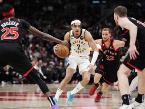 Indiana Pacers guard Andrew Nembhard (2) drives between Raptors' Chris Boucher (25), Malachi Flynn (22) and Jakob Poeltl (19) during the second half in Toronto on Wednesday, March 22, 2023.