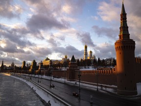 Sunset lights the Kremlin and frozen Moscow River in Moscow, Russia, Sunday, Jan. 16, 2022.