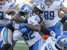 Dec 24, 2022; Charlotte, North Carolina, USA; Detroit Lions running back D'Andre Swift (32) is tackled by Carolina Panthers linebacker Frankie Luvu (49) during the second half at Bank of America Stadium.