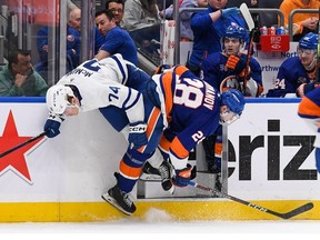 Mar 21, 2023; Elmont, New York, USA; New York Islanders defenseman Alexander Romanov (28) checks Toronto Maple Leafs center Bobby McMann (74)  during the third period at UBS Arena.