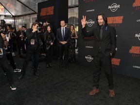 Keanu Reeves, right, star of "John Wick: Chapter 4," arrives at the premiere of the film, Monday, March 20, 2023, at the TCL Chinese Theatre in Los Angeles.