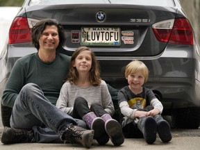 Peter Starostecki and his kids Sadie, center, and Jo Jo, pose behind their car with the vanity licence plate that the state of Maine has deemed in appropriate, Wednesday, March 8, 2023, in Poland, Maine. The vegan family's car will soon have a randomly selected plate.