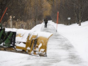 A city tractor clears snow from a public walkway following a winter storm that affected southern Ontario, in Toronto, on Thursday, Feb., 23, 2023. The cities of Mississauga and Oshawa have said reports of clashes between snow plow operators and residents have increased.