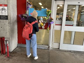 A person adds to the memorial for 16-year-old Gabriel Magalhaes at the Keele Street subway station in Toronto, Monday, March 27, 2023.