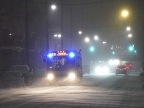 A transit bus drives through a snowstorm in Toronto on Friday, March 3, 2023.