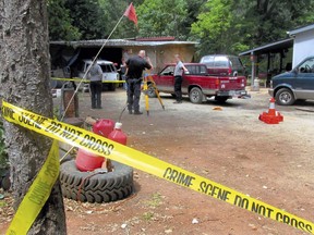 Investigators comb a property outside Wilderville, Ore., on Saturday, May 30, 2015, the morning after Oregon State Police troopers shot Robert Box.
