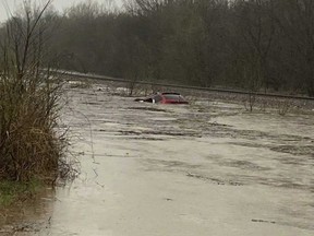 In this photo provided by Layton Hoyer, a red SUV is seen submerged in floodwater on Old Ritchey Road in Granby, Mo., early Friday, March 24, 2023.