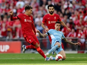 Soccer Football - FA Cup Semi Final - Manchester City v Liverpool - Wembley Stadium, London, Britain - April 16, 2022 Manchester City's Joao Cancelo in action with Liverpool's Roberto Firmino and Mohamed Salah.