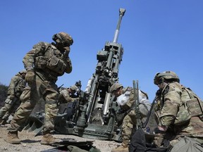 U.S. Army soldiers work on a M777 howitzer during a joint military drill between South Korea and the United States at Rodriguez Live Fire Complex in Pocheon, South Korea, Sunday, March 19, 2023. North Korea launched a short-range ballistic missile toward the sea on Sunday, its neighbors said, ramping up testing activities in response to U.S.-South Korean military drills that it views as an invasion rehearsal.