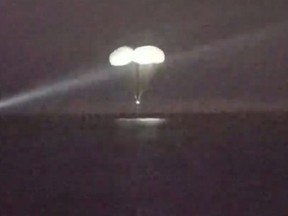In this image from video made available by NASA, a SpaceX capsule, slowed by parachutes, approaches the surface of the waters of the Gulf of Mexico off Tampa, Fla., as it returns to Earth with Expedition 68 Flight Engineers Anna Kikina of Roscosmos, Josh Cassada and Nicole Mann from NASA, and Koichi Wakata of JAXA (Japan Aerospace Exploration Agency) after a five-month mission in the International Space Station, on Saturday, March 11, 2023. (NASA via AP)