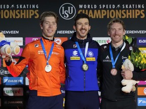 Davide Ghiotto of Italy, centre and gold medal, Jorrit Bergsma of the Netherlands, left and silver medal, Ted-Jan Bloemen of Canada, right and bronze medal, celebrate on the podium of the 10,000m Men event of the Speedskating Single Distance World Championships at Thialf ice arena Heerenveen, Netherlands, Sunday, March 5, 2023.