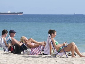 Airports and airlines are preparing for a surge in passengers ahead of spring break. Beachgoers face the sun on Fort Lauderdale beach, Thursday, Dec. 22, 2022, in Fort Lauderdale, Fla.