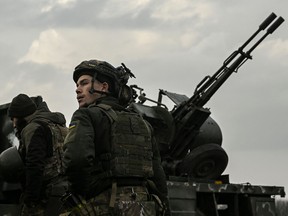 A Ukrainian serviceman stands in front of an anti-aircraft machine gun, in Siversk, Donbas region, on March 7, 2023.