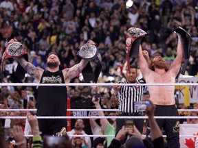 Canadians Kevin Owens (left) and Sami Zayn celebrate after becoming the Undisputed WWE tag team champions on the first night of WrestleMania 39 at Sofi Stadium in Los Angeles on April 1, 2023. Owens and Zayn, lifelong friends, defeated The Usos to capture their first tag title together in the WWE.