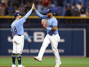 Harold Ramirez #43 of the Tampa Bay Rays high fives Brandon Lowe #8 after beating the Oakland Athletics at Tropicana Field on April 08, 2023.
