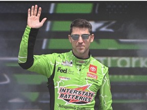 Denny Hamlin, driver of the Interstate Batteries Toyota, waves to fans as he walks onstage during driver intros prior to the NASCAR Cup Series EchoPark Automotive Grand Prix at Circuit of The Americas on March 26, 2023 in Austin, Texas.