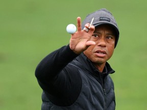 Tiger Woods of the United States catches a ball.