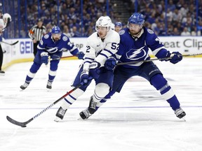 Noel Acciari of the Toronto Maple Leafs and Victor Hedman of the Tampa Bay Lightning fight for the puck in the third period during Game Three of the First Round of the 2023 Stanley Cup Playoffs at Amalie Arena on April 22, 2023 in Tampa, Florida.