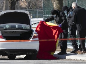 Police at the scene where a man and a woman were found dead inside a taxi in St-Léonard March 19, 2021.
